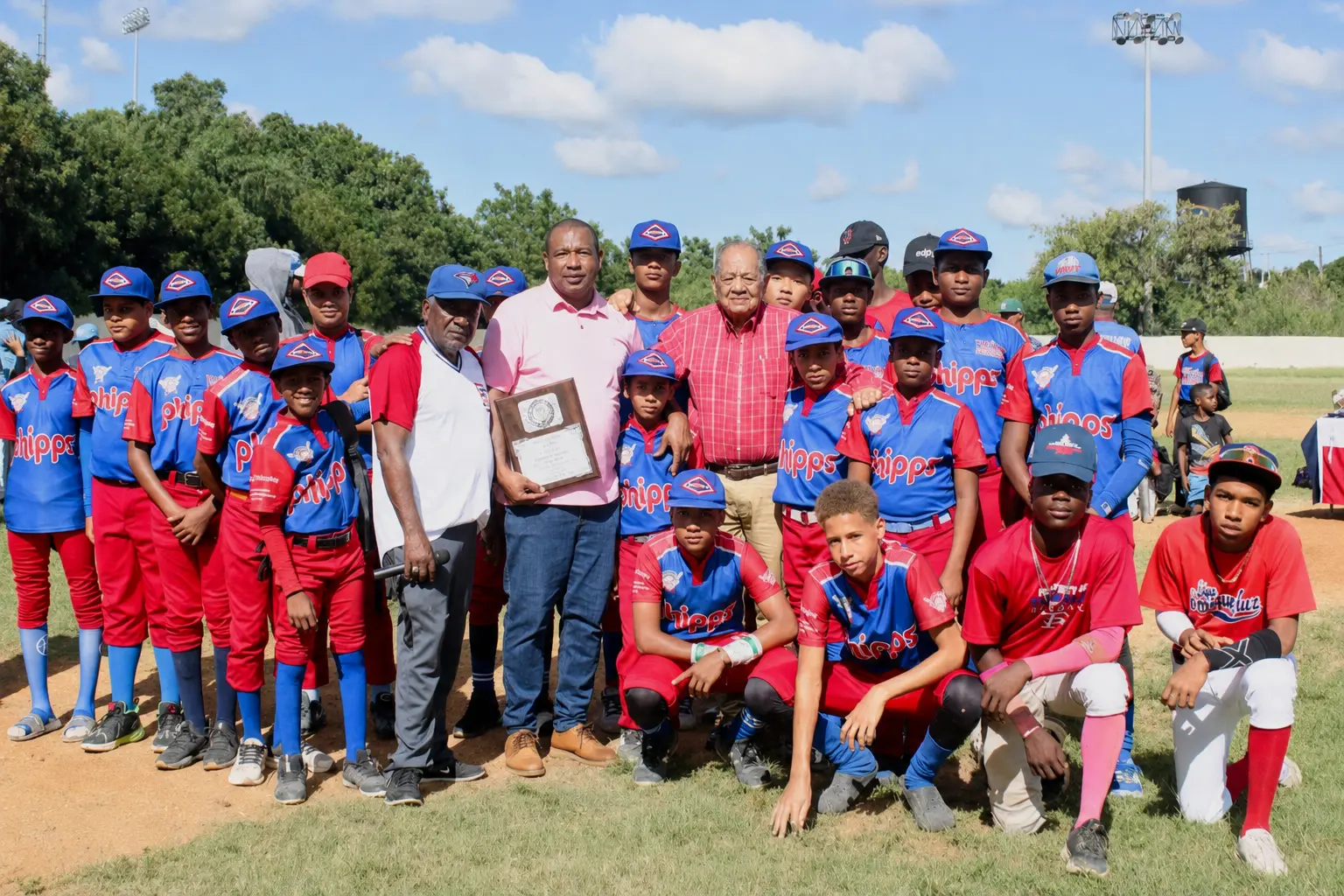 Ramón de los Santos junto a un equipo juvenil de béisbol